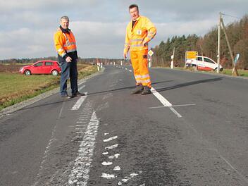 Ein schweres landwirtschaftliches Fahrzeug ist auf der Straße zwischen Heinersreuth und Trebgast über die frisch aufgebrachte Mittelstreifen-Markierung gefahren und hat die Farbe über die ganze Straße verteilt. Straßenmeister Eckhard Schrepfer (links) und sein Stellvertreter Hans-Günther Dörfler von der Straßenmeisterei Leuchau begutachten den Schaden. Foto: Jürgen Gärtner