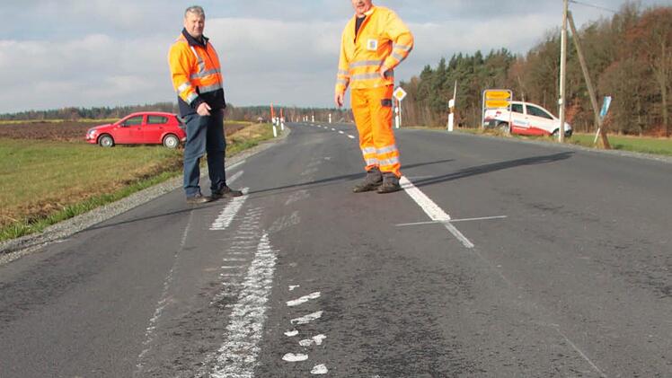 Ein schweres landwirtschaftliches Fahrzeug ist auf der Straße zwischen Heinersreuth und Trebgast über die frisch aufgebrachte Mittelstreifen-Markierung gefahren und hat die Farbe über die ganze Straße verteilt. Straßenmeister Eckhard Schrepfer (links) und sein Stellvertreter Hans-Günther Dörfler von der Straßenmeisterei Leuchau begutachten den Schaden. Foto: Jürgen Gärtner