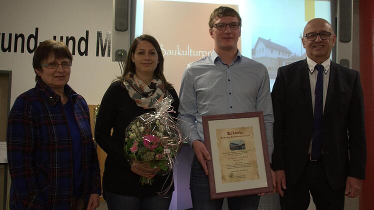 Sie retteten ein ortsbildprägendes Wohnhaus in der Mitte von Heilgersdorf vor dem Verfall und verwandelten es in ein Schmuckstück: Mona und Christoph Marquardt. Dafür wurde das frischgebackene Ehepaar in der Jahresabschlusssitzung des Seßlacher Stadtrats am Dienstagabend in der Aula der Grund- und Mittelschule Seßlach von den Bürgermeistern Wolfgang Pfister (rechts) und Renate Schubart-Eisenhardt (links) mit dem "Baukulturpreis" der Stadt ausgezeichnet. Foto: Bettina Knauth