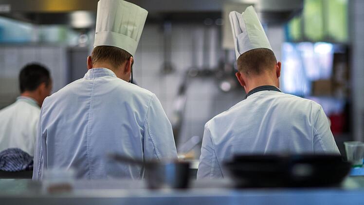 Zwei junge Köche arbeiten an ihren Speisen. Durch die gute Lage auf dem Arbeitsmarkt hat die Gastronomie Probleme, Mitarbeiter zu finden.  Foto: Jens Büttner, dpa