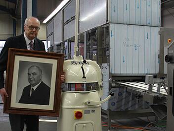 Wolfgang Schröder steht mit einem Bild seines Vaters und Erfinder des Halbautomaten, Herbert Schröder, neben dem Fortuna-Klassiker. Im Hintergrund ist eine der Großanlagen zu sehen. Foto: Thomas Heuchling