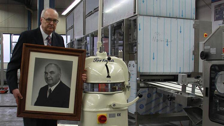 Wolfgang Schröder steht mit einem Bild seines Vaters und Erfinder des Halbautomaten, Herbert Schröder, neben dem Fortuna-Klassiker. Im Hintergrund ist eine der Großanlagen zu sehen. Foto: Thomas Heuchling