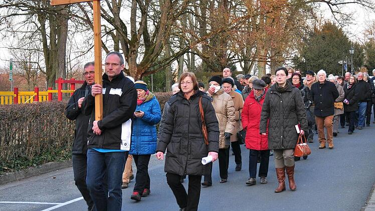 Einen etwas anderen Kreuzweg bot die katholische Pfarrei St. Kilian am Sonntag an. Gemeinsam mit Diakon Manfred Griebel (links) und der Pfarrgemeinderatsvorsitzenden Elisabeth Graßer (hinter dem Kreuz rechts) zogen knapp 60 Gläubige durch die Stadt und feierten in der Ritterkapelle den Abschluss. Foto: Ulrike Langer