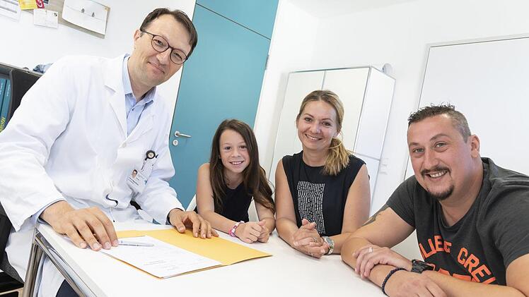 Die Familie von Lea sitzt mit Professor Doktor Markus Metzler beim Nachsorgegespräch. Foto: Michael Rabenstein/Uni-Klinikum Erlangen
