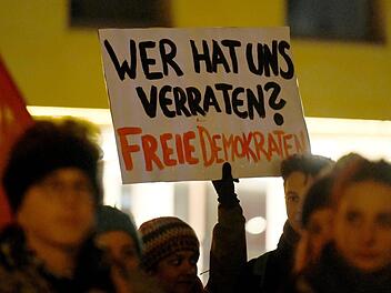 Bayreuth: Demonstranten halten bei einer Kundgebung ein Schild mit der Aufschrift «Wer hat uns verraten? Freie Demokraten» in die Höhe. Einige Menschen haben mit einer spontanen Kundgebung gegen die Wahl des FDP-Politikers Kemmerich zum Thüringer Ministerpräsidenten mit Stimmen der AfD protestiert. Foto: Nicolas Armer/dpa