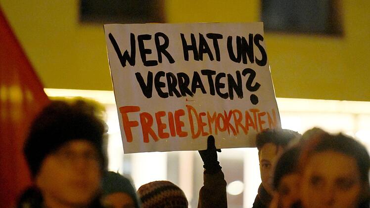 Bayreuth: Demonstranten halten bei einer Kundgebung ein Schild mit der Aufschrift «Wer hat uns verraten? Freie Demokraten» in die Höhe. Einige Menschen haben mit einer spontanen Kundgebung gegen die Wahl des FDP-Politikers Kemmerich zum Thüringer Ministerpräsidenten mit Stimmen der AfD protestiert. Foto: Nicolas Armer/dpa