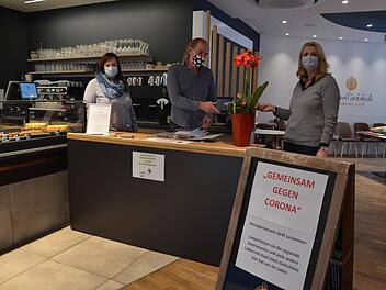 Gaby Richter und ihr Bruder Jürgen Rattmann starten heute ihre zweite Gutscheinaktion. Der Tisch steht im Café "Handgebäck", links die Geschäftsleiterin Elena Frühwald. Fotos: Bernhard Panzer