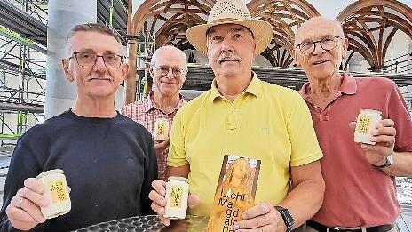 Hans Zenk, Pfarrer P. Markus Reis, Paul Ziegler und Hans Beudert (von links nach rechts) präsentieren Infoblatt und Kerzen zur neuen Spendenaktion „Ein Licht für Magdalena“.
