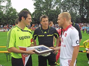 Einer der H&ouml;hepunkte in der j&uuml;ngeren Geschichte des 1. FC Ha&szlig;furt war das Gastspiel des damaligen Fu&szlig;ball-Bundesligisten 1. FC N&uuml;rnberg am 17. Juli 2010 vor 3200 Zuschauern. Die Kapit&auml;ne Thomas Borst (links, FCH) und Andreas Wolf tauschen Erinnerungsgeschenke aus. In der Mitte Schiedsrichter Stein aus Homburg am Rhein.  Foto: G&uuml;nther Geiling