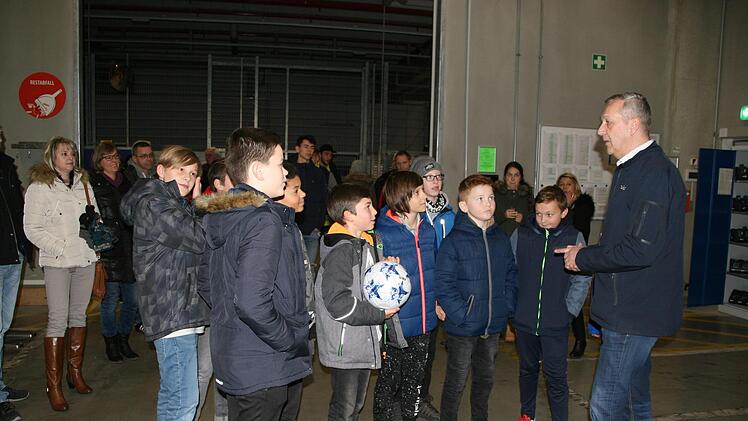 Ausbildungsleiter Werner Fischer führt eine Gruppe junger Fußballer durch das Logistikzentrum. Foto: Sylvia Hubele