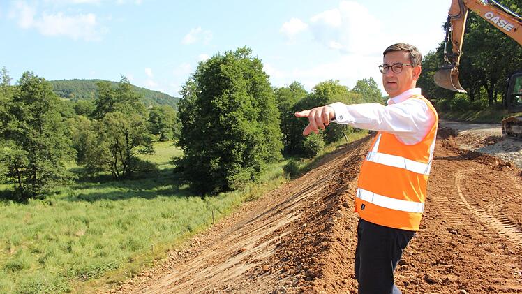 Rüdiger Köhler zeigt den schrägen Hangbewuchs. Hier wurde die Straße bisher schlecht entwässert, weshalb es zum Hangrutsch kam.  Foto: Julia Raab