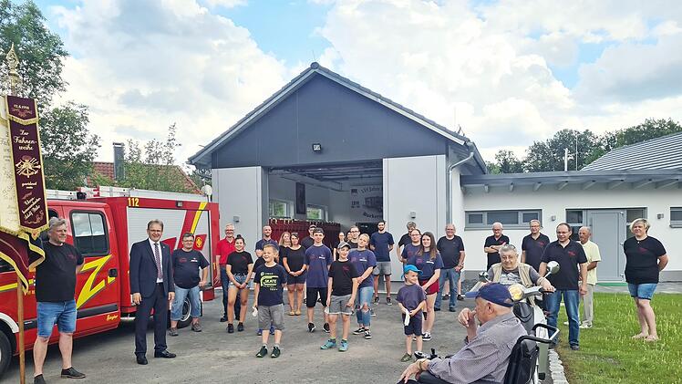 Freudestrahlend und mit Abstand zeigten sich die Wehrleute der Freiwilligen Feuerwehr Burkersdorf mit (von links) Fahnenträger Andreas Gehring und Bürgermeister Bernd Rebhan vor dem neuen Feuerwehrgerätehaus in Burkersdorf. Mit im Bild sind auch Ortssprecher Volker Wündisch (Vierter von links) und einige Zaungäste, die gerne Zeugen des Umzugs ins neue Gerätehaus waren.