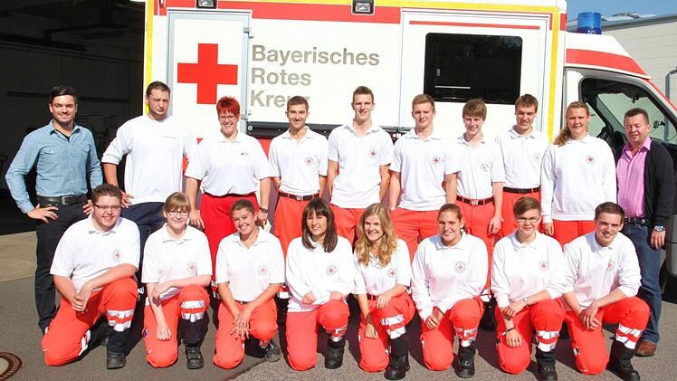 16 neue Rettungsdiensthelfer sind bei einem Fachlehrgang Rettungsdienst beim BRK-Kreisverband Haßberge in vier Wochen ausgebildet worden. Sie alle werden sich künftig im Rettungsdienst engagieren. Das Foto zeigt sie mit den Ausbildern Daniel Schirmer (links) und Wolfgang Brühl (rechts).  Foto: Michael Will
