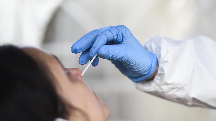 Eine Mitarbeiterin eines Testzentrums nimmt einen Nasenabstrich f&uuml;r einen Corona-Schnelltest.