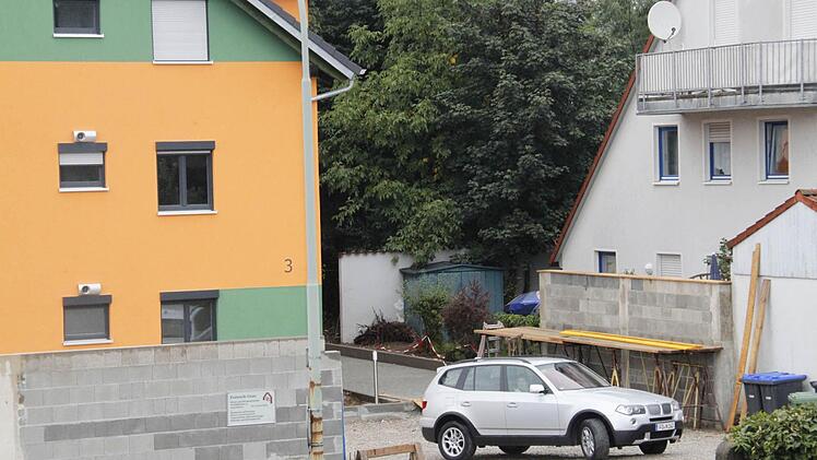 Hinter dem Fahrzeug, das das Grundstück Hainbrunnenstraße 3  verläßt, steht die Mauer vor der Terrasse des Nachbarhauses.