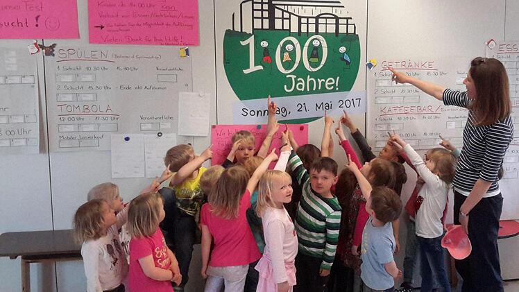 Alles dreht sich momentan um das bevorstehende Jubiläum "100 Jahre Kindergarten Oberleichtersbach". Das haben inzwischen auch schon die kleinen Mädchen und Jungen mit ihrer Erzieherin Karin Keßler (rechts) verinnerlicht und weisen gern auf das große Ereignis hin. Foto: Rolf Pralle