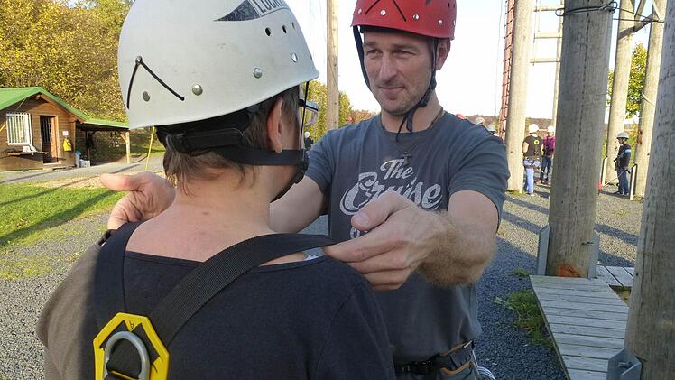 Sensibler Bereich: Im Hochseilgarten der Jugendbildungsstätte Volkersberg müssen ehrenamtliche Trainer wie Erik Mehlmann die Klettergurte kontrollieren. Umso wichtiger ist, dass jeder Schritt angekündigt und erklärt wird, dass alles vor der Gruppe stattfindet und auf notwendige Kontakte beschränkt bleibt. Foto: privat