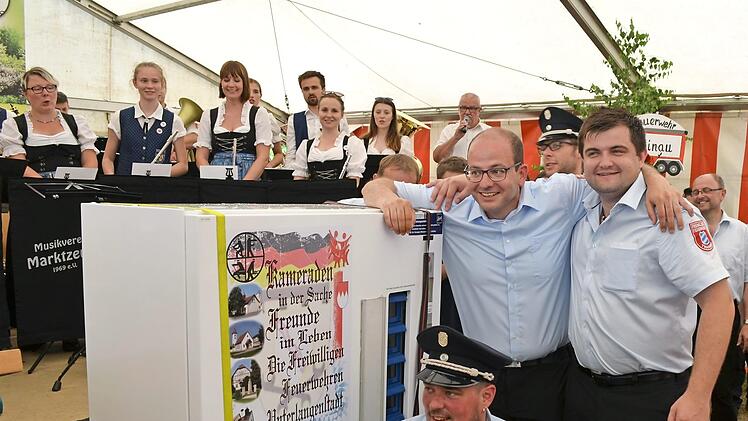 Niklas Welscher (stehend rechts) überraschte als Vorsitzender des Patenvereins FFW Trainau die Unterlangenstadter Feuerwehr mit Kommandant Sascha Rauh (kniend) und Vorsitzendem Jan Millitzer (stehend links) mit dem Jubiläumsgeschenk.  Foto: Thomas Micheel