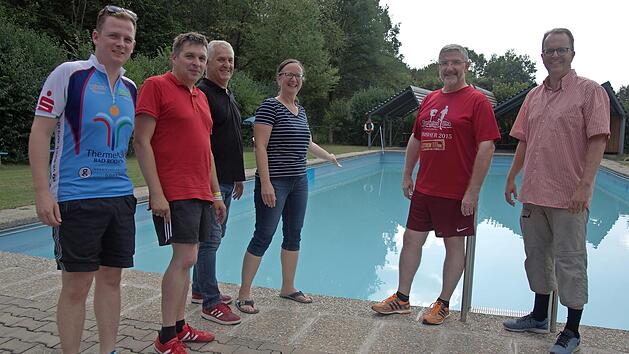Tobias Ehrlicher, Carsten H&ouml;llein, Dominik Fick, Martina Kilian, Landrat Michael Busch und ihr Gast Markus Rinderspacher stehen vor dem Becken des Autenhausener Freibades und besprechen die Problematik der Wasserqualit&auml;t und des Umbaus der Anlage zu einem Naturbad.  Foto: Bettina Knauth