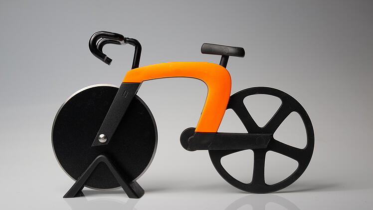 bicycle model used as a pizza cutter utensil orange framed bike with black wheels on a white background