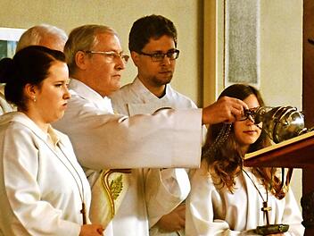 Diakon Michael Schlereth schwingt hier beim Festgottesdienst den Weihrauch-Kessel über dem Evangelium. Begleitet wird er dabei von den Ministranten Selina Schmitt (links) und Ramona Metz (rechts) sowie Praktikant Martin Kuhnert.