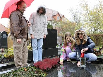 Clemens, Ute, Annika und Isabel Raab am Grab von Opa Josef auf dem Burgebracher Friedhof. Foto: Barbara Herbst