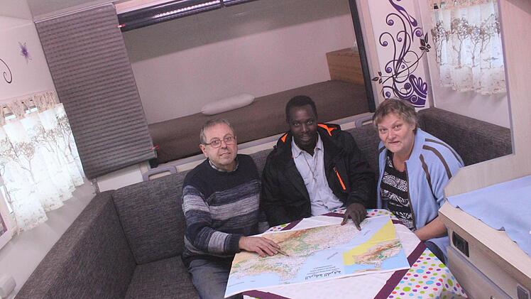 Karin und Theo Wittmann sowie ihr Schwiegersohn Bruno Diouf (Mitte) sitzen im Kofferaufbau des 7,5-Tonners und gehen noch einmal die Reiseroute durch, bevor sie am 3. Dezember von Grundfeld aus in den Senegal fahren.  Foto: Matthias Einwag