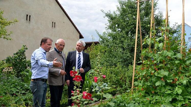 Markus Lamm (ganz links im Bild) erläutert Bezirkstagspräsident Günther Denzler und Landrat Johann Kalb seinen Garten.