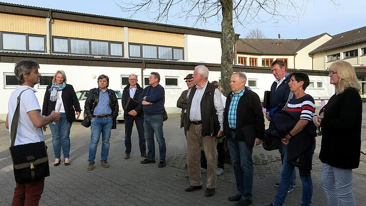 Bei der Ortsbegehung hören die Gemeinderäte auf dem Schulhof dem Architekten Norbert Siewertsen zu. Foto: Dagmar Niemann