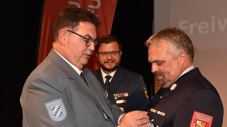 Der Kommandant der Freiwilligen Feuerwehr Haßfurt, Martin Volpert (rechts), wurde vom THW mit dem Helferabzeichen in Gold ausgezeichnet. Mit im Bild der Geschäftsführer der THW-Geschäftsstelle Bamberg, Curd Mohr (links) und der Ortsbeauftragte des THW-Ortsverbandes Haßfurt, Christian Günther.