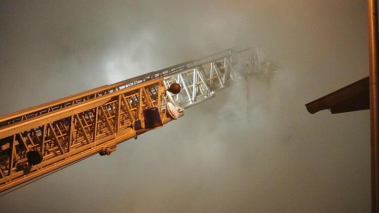 Der Feuerwehrmann im Drehleiterkorb ist in den dichten Rauchwolken völlig verschwunden.