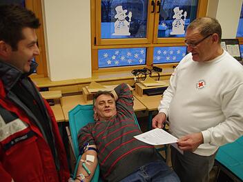 BRK-Ehrenamtsmanager Ralf Schmidt (links) und der Blutspende-Beauftragte vor Ort, Ingbert Weigelt (rechts), freuen sich, dass Konrad Fehn die 16 00 Blutspender-Marke in Windheim geknackt hat.  Fotos: Heike Schülein