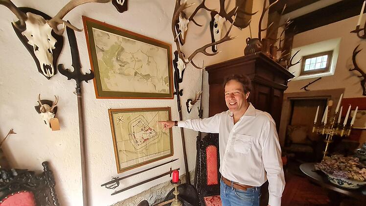Karl Ludwig Freiherr zu Guttenberg im Jagdhaus. Auf den antiken Karten der Burg ist zu erkennen, dass die Salzburg einst mitten in Weinbergen stand.  Foto: Susanne Will