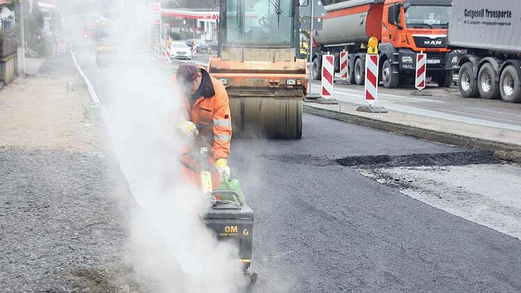 Da dampft es gewaltig, als der Rüttler den Rand der Asphaltschicht befestigt. Die Walze kommt nicht ganz bis zum Bordstein. Foto: Friedwald Schedel