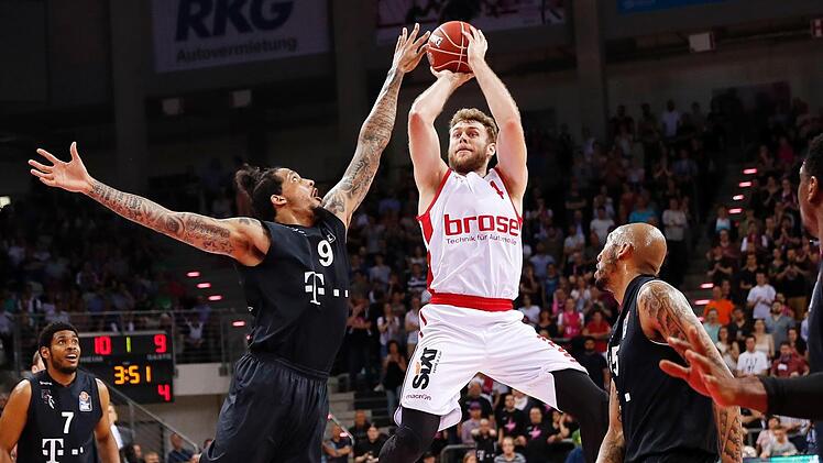 Nicolo Melli steigt am Zonenrand hoch und drückt ab; links der Bonner Julian Gamble, rechts sein Teamkollege Kenneth Horton. Foto: Daniel Löb