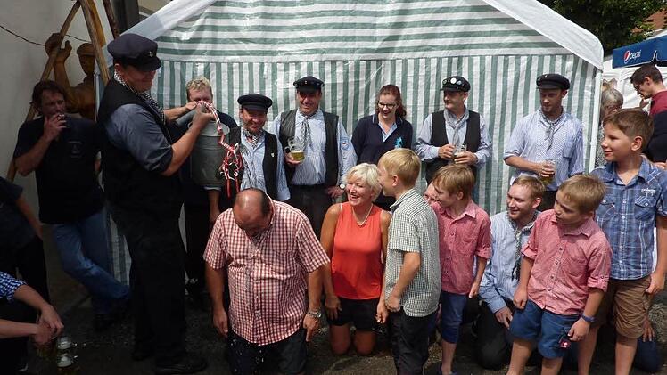 Genüsslich nahm Floßmeister Michael Thiemann mit Rodachwasser die Flößertaufe bei Bürgermeister Knut Morgenroth (links) vor. Rechts daneben Angelika Woll und die neuen Nachwuchsflößer. Foto: Gerd Fleischmann