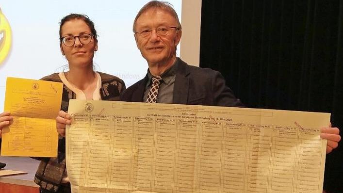 "Handliches Tischtuchformat": Roland Neubauer hat den Stimmzettel für die Stadtratswahl in Coburg aufgefaltet. Die Wahlkabinen sind groß genug, um den Zettel ausbreiten zu können, versichert Roland Neubauer. Stellvertretende Wahlleiterin Tina Möller zeigt zum Vergleich den Stimmzettel für die Oberbürgermeisterwahl in Coburg. Foto: Simone Bastian
