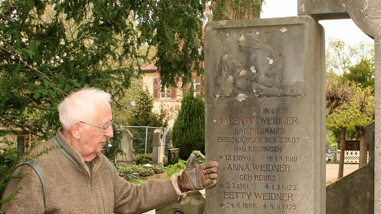 Werner Eberth entfernt Moose und Flechten am Grabmal des Bildhauers Valentin Weidner.  Foto: Vogel