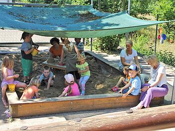 Die Leiterin des Kindergartens Daniela Werner (rechts) und ihre beiden Kolleginnen Oksana Schwindt und Jutta Weidner (im Sandkasten) spielen mit den Kindern. Foto: Julia Raab