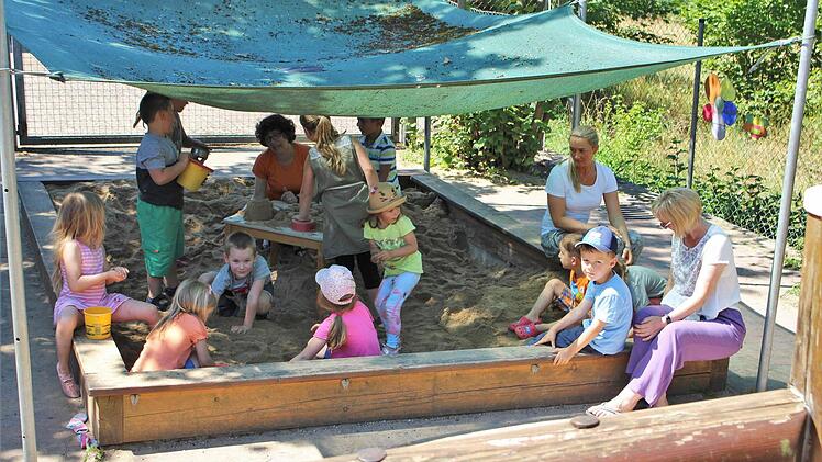 Die Leiterin des Kindergartens Daniela Werner (rechts) und ihre beiden Kolleginnen Oksana Schwindt und Jutta Weidner (im Sandkasten) spielen mit den Kindern. Foto: Julia Raab
