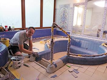 Fliesenleger Damasti fliest sorgfältig den neuen Einstieg ins Becken. Foto: Monika Schütz