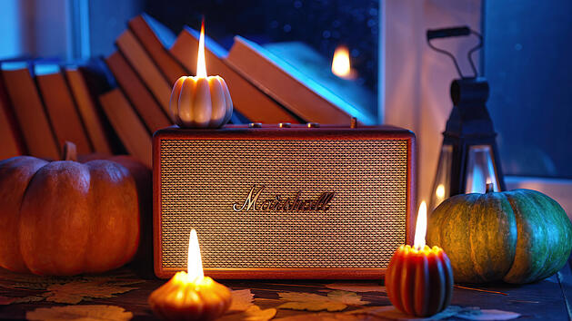November 2023. Autumn music ambience. Marshall bluetooth speaker Acton III among candles, books near rainy window.