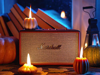 November 2023. Autumn music ambience. Marshall bluetooth speaker Acton III among candles, books near rainy window.