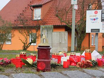 An der Stelle, an der Janina von einer Kugel getroffen wurde, sind Kerzen aufgestellt. Der mutmaßliche Todesschütze wohnte im Haus im Hintergrund, vom Garten aus feuerte er seine Waffe ab. Das Bild entstand im Januar dieses Jahres, wenige Tage nach der Tat. Foto: Andreas Lösch/Archiv
