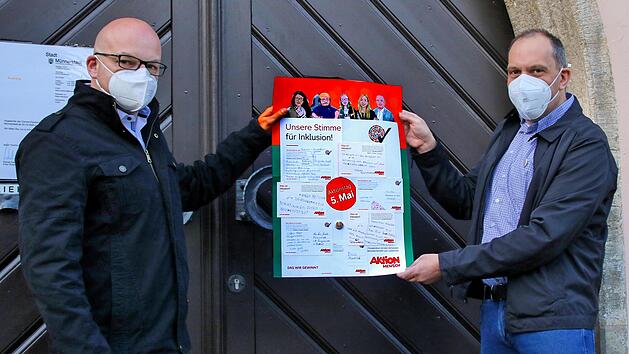 Andreas Schmidt, Leiter der Offenen Behindertenarbeit des Dominikus-Ringeisenwerks (rechts) &uuml;berreichte B&uuml;rgermeister Michael Kastl (links) einen Bogen mit den Ergebnissen der Kartenaktion. Einige behinderte Menschen hatten auf den Karten Schwachstellen in der Stadt aufgezeigt. Foto: Dieter Britz