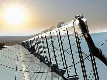Die Sonne scheint über einem Parabolspiegel mit Solarreceivern Foto: Schott/dpa