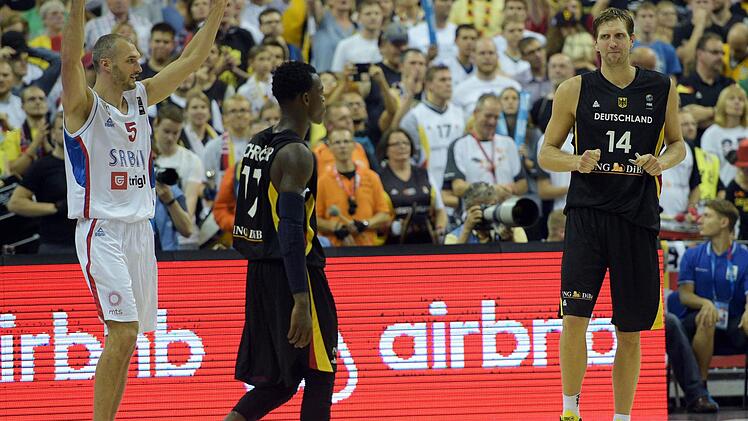 Am Ende jubelten die Serben. Hier reißt Marko Simonovic (links) die Arme hoch, während Dirk Nowitzki (rechts) und Dennis Schröder enttäuscht vom Parkett gehen. Foto: Rainer Jensen/dpa