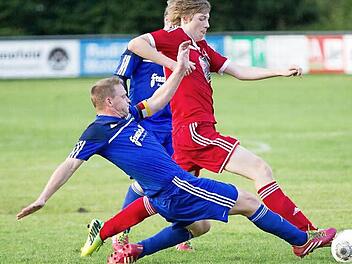 Meeders Christian Dreßel (rotes Trikot) stürmt in dieser Szene an Mario Totzauer vorbei, der noch versucht mit einem langen Bein den Ball zu erreichen. Am Ende gewann Gastgeber Mitwitz mit 2:0. Foto: Heinrich Weiß