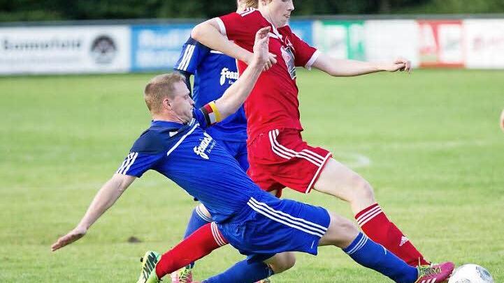 Meeders Christian Dreßel (rotes Trikot) stürmt in dieser Szene an Mario Totzauer vorbei, der noch versucht mit einem langen Bein den Ball zu erreichen. Am Ende gewann Gastgeber Mitwitz mit 2:0. Foto: Heinrich Weiß