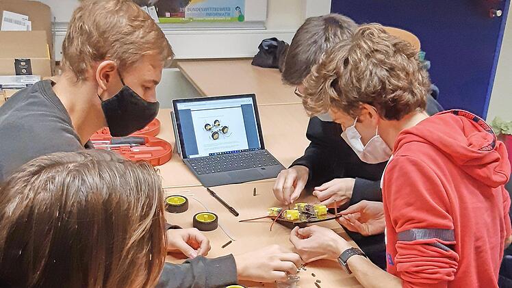 Schüler des P-Seminars Robotik am Lichtenfelser Meranier-Gymnasium bauen das Modell eines Autos, das ab kommenden Schuljahr Siebtklässer selbst programmieren können.  Foto: Sebastian Schyma